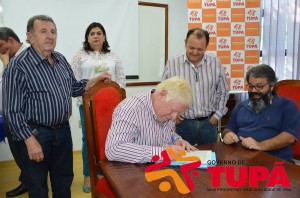 Luizinho (sentado) observa o prefeito Manoel Gaspar assinar escritura de aquisição do Country
