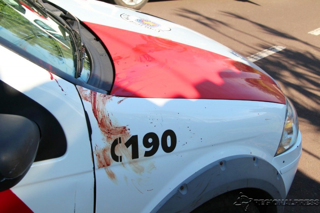 Marcas de sangue deixadas pelo assassino ao encostar na viatura.